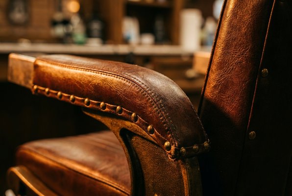 Deep brown leather barber chair armrest detail